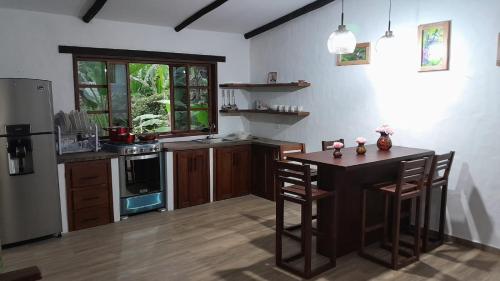 cocina con mesa de madera y cocina con nevera en CABAÑAS DOS RIOS, en Cotacachi