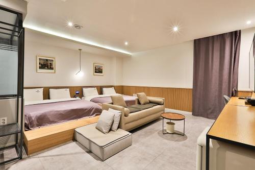 um quarto de hotel com uma cama e um sofá em Brown Dot Hotel Jeonggwan em Busan