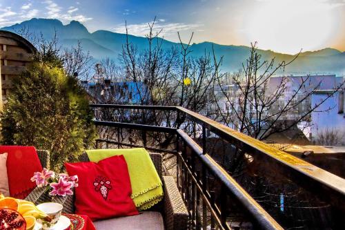 a balcony with a table and colorful pillows on it at Apartamenty Zakopane Krupówki in Zakopane