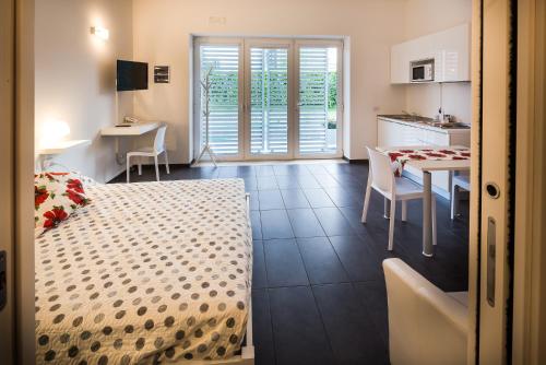 a bedroom with a bed and a table and a kitchen at Residence Peloni in Arezzo