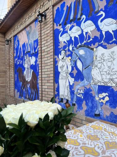 a mural on the side of a building with a painting at Hotel Caravan Serail in Samarkand