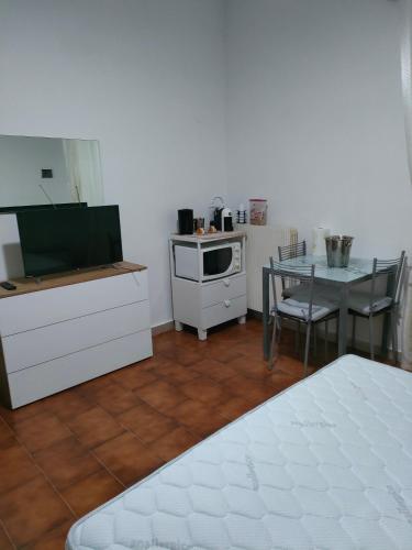a room with a kitchen with a table and a stove at La casa di Rosy in Porto Santo Stefano