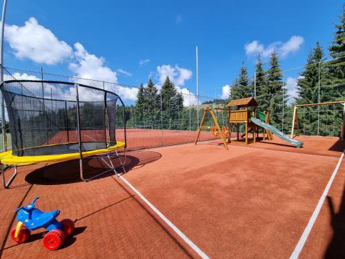 a playground with a toy on a tennis court at Resort EuroPark Fundata in Fundata