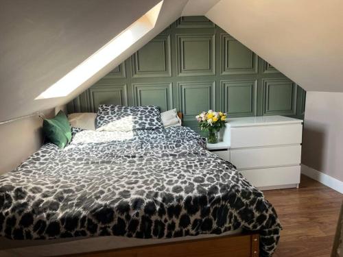 a bedroom with a black and white comforter on a bed at Bright, comfy and peaceful house in Inverkeithing