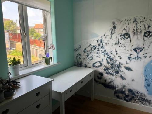 a room with a mural of a white tiger on the wall at Bright, comfy and peaceful house in Inverkeithing