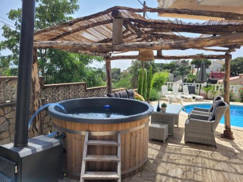 a hot tub on a patio with a pergola at Casa Felic 12 personen, familiehuis met hottub in Lloret de Mar