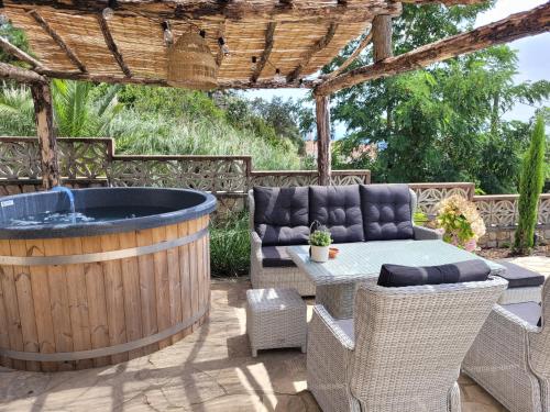 um pátio com uma banheira de hidromassagem, uma mesa e cadeiras em Casa Feliç (10-12 personen) em Lloret de Mar