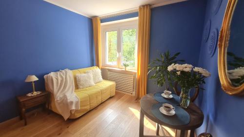 a living room with a yellow couch and a table at Apartament Kraszewskiego - Retro, blisko Starówki, koło parku, ogród dla gości, rowery free in Toruń