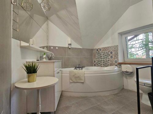 ein weißes Badezimmer mit einer Badewanne und einem Waschbecken in der Unterkunft Hotel Villa Hubertus Kutno in Kutno