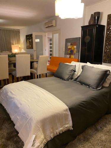 a bedroom with a large bed with chairs and a table at Luxury Family suite for 4 in Caxias