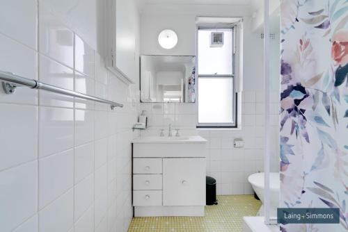 a white bathroom with a sink and a toilet at TC GARDENS 12 in Armidale
