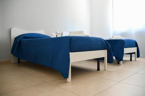 a bed with a blue blanket on top of it at Dino's Rooms in Lioni
