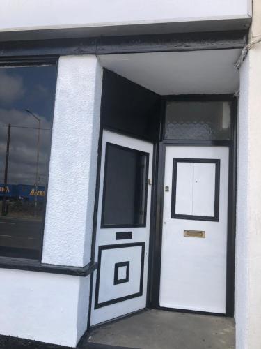 a white building with a white door and windows at AC Lounge 125 in Rochford