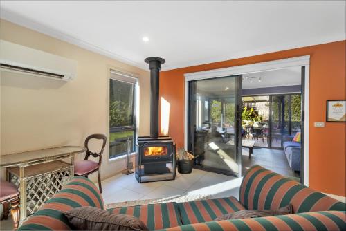 a living room with a couch and a wood stove at Madsen Retreat in Penguin
