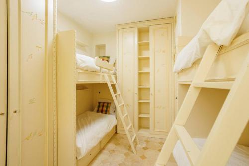a small room with bunk beds and a ladder at Hovevey Tsiyon Luxury Apartment By Nimizz in Jerusalem