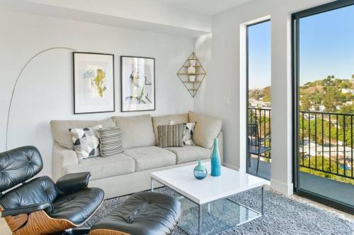 uma sala de estar com um sofá e uma mesa em Luxury retreat with rooftop, hot tub & views em Los Angeles