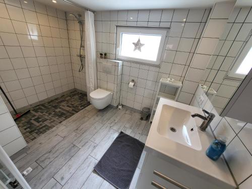 a bathroom with a toilet and a sink and a window at Ferienhaus Linda in Wanna