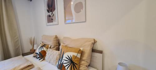 a couch with pillows on it in a room at NAVIA Mira - Design Apartment - Ruhig, Modern & Gemütlich in Dernbach