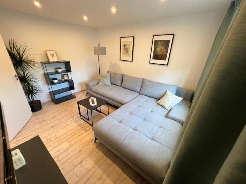 a living room with a couch and a table at NAVIA Mira - Design Apartment - Ruhig, Modern & Gemütlich in Dernbach
