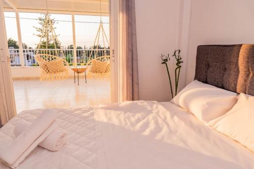 a bedroom with a bed and a view of a balcony at Minodoras Guesthouse in Platánion