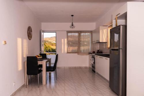 a kitchen with a table with chairs and a refrigerator at Minodoras Guesthouse in Platánion