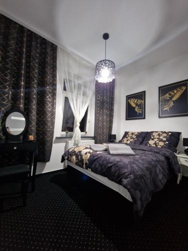 MAGIC HOME Apartamenty في رودا شلاسكا: غرفة نوم بسرير وثريا