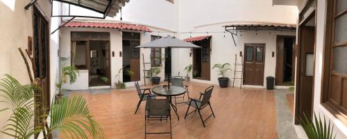 a patio with a table and chairs and an umbrella at Bleu Downtown in Campeche