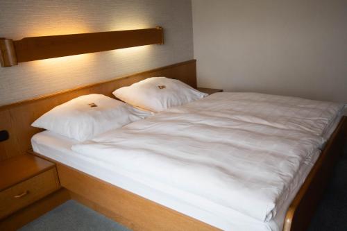 a large white bed with two pillows on it at Landhotel Jägerhof in Bischofsgrün