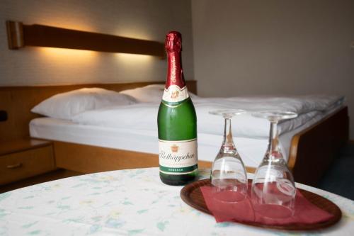 een fles wijn en twee glazen op een tafel bij Landhotel Jägerhof in Bischofsgrün