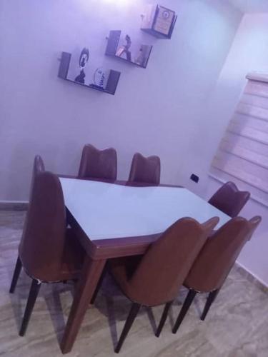 uma mesa de jantar com quatro cadeiras à volta em Home of peace, joy and rest em Benin City