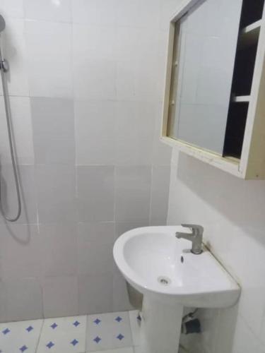 uma casa de banho branca com um lavatório e um espelho em Home of peace, joy and rest em Benin City