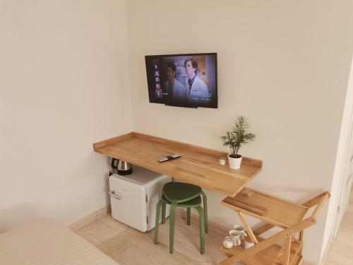 a room with a desk and a tv on a wall at Motyl Apartamenty Studio in Bytom