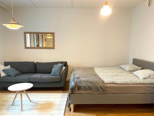 a living room with a bed and a couch at Seaside Apartment in Helsinki