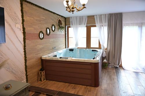 ein großes Bad mit einer großen Badewanne in einem Zimmer in der Unterkunft Conacul Radacinilor in Petroşani
