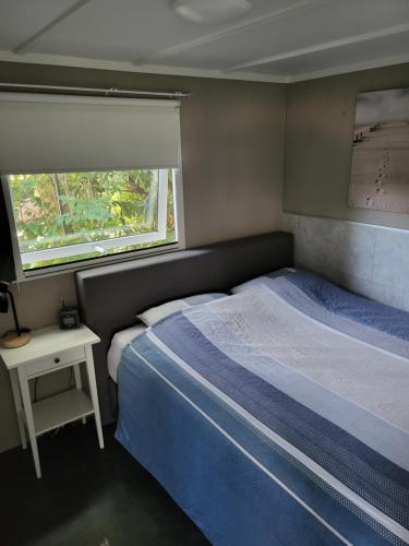 een kleine slaapkamer met een bed en een raam bij Chalet Renswouw in Renswoude