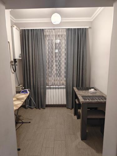 a room with a table and a window with curtains at Cosy Home in Gyumri