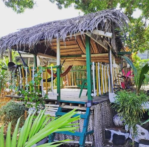 a tree house with a deck and a thatch roof at LE CHISSIOUA in Sada