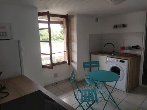 une cuisine avec une table et des chaises ainsi qu'un lave-linge dans l'établissement Maison Chez Catherine, à Baix
