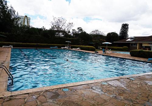 a large swimming pool with blue water in a yard at Rooftop Haven Allsoaps in Nairobi
