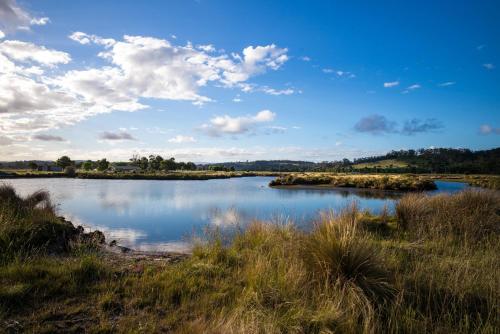 a river with islands in the middle of a field at Pelican Point Sanctuary in St Helens