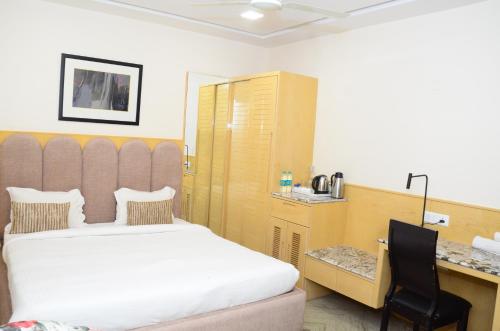 a hotel room with a bed and a desk and a desk at CRYTSAL RESIDENCY in Rānchī