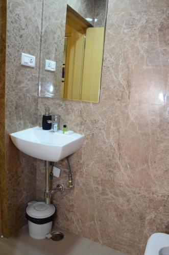 a bathroom with a sink and a mirror and a toilet at CRYTSAL RESIDENCY in Rānchī