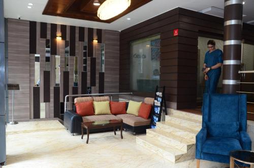 a man standing in a lobby with a couch and chairs at CRYTSAL RESIDENCY in Rānchī
