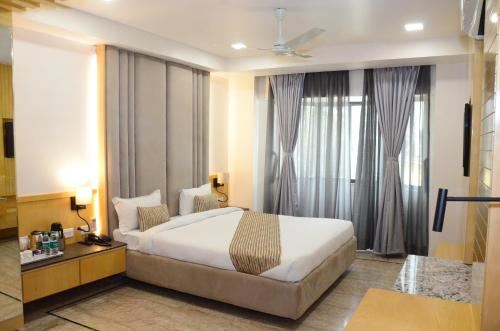 a bedroom with a large white bed in front of windows at CRYTSAL RESIDENCY in Rānchī