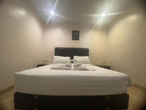 a bedroom with a bed with two teddy bears on it at Dna Fun Zone Pekanbaru in Pekanbaru
