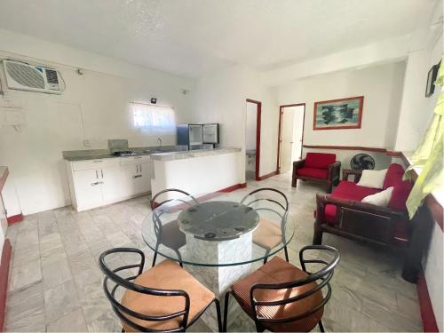 a living room with a glass table and chairs at Beach Road Apartments in Matabungkay