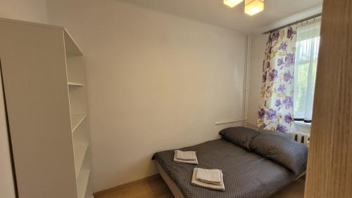 um pequeno quarto com uma cama e uma janela em Apartament Alek Krosno em Krosno