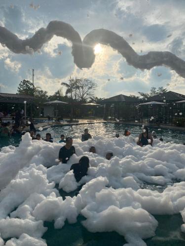 people are sitting in foam bubbles in a swimming pool at Dna Fun Zone Pekanbaru in Pekanbaru