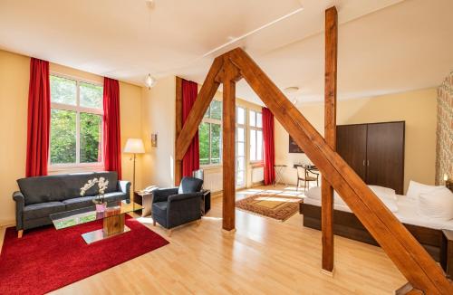 ein großes Wohnzimmer mit einem Bett und einem Wohnzimmer in der Unterkunft Kulturhotel Kaiserhof in Bad Liebenstein
