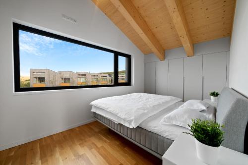 1 dormitorio con cama y ventana grande en Vánice pod Klínovcem, en Loucná pod Klínovcem